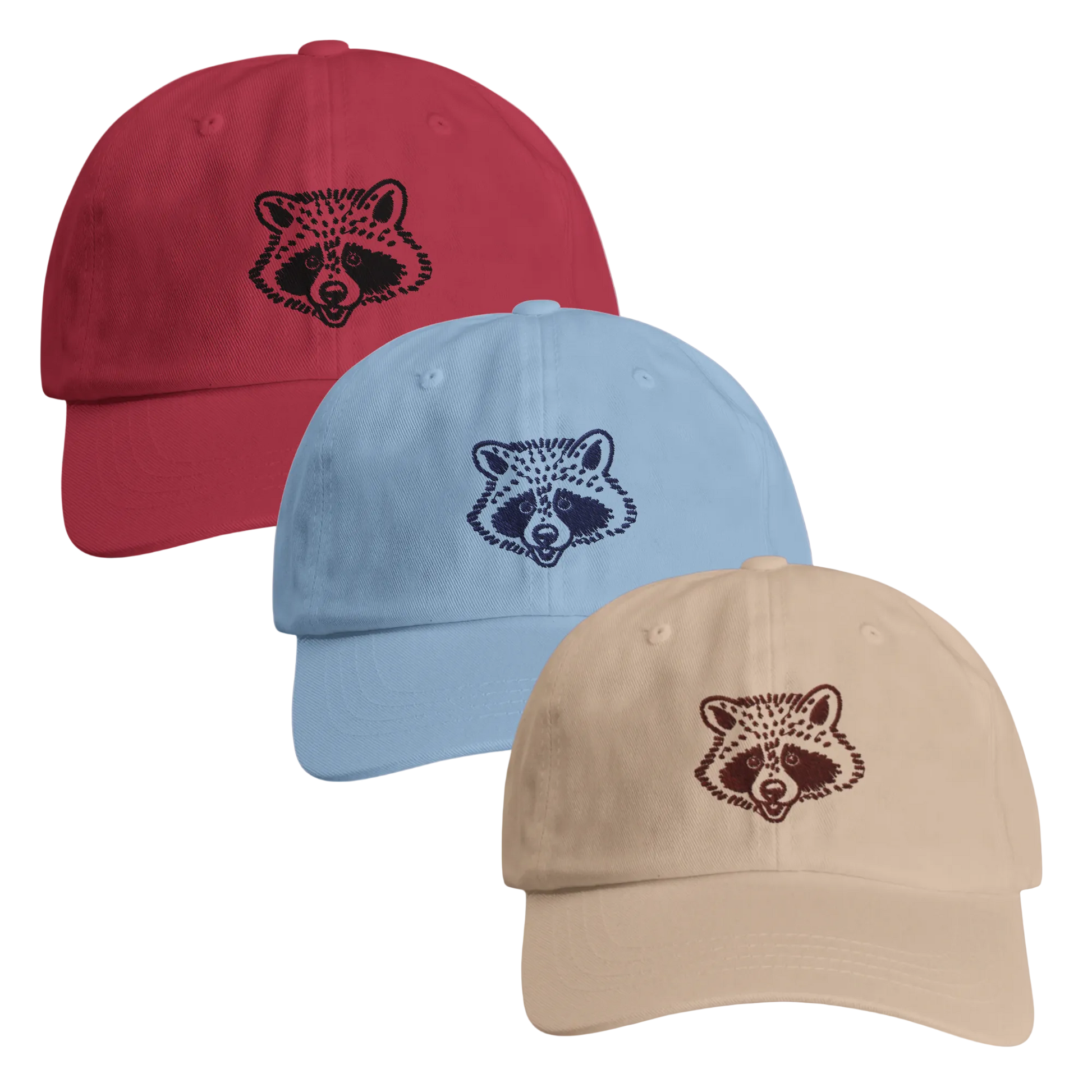 Three baseball caps in red, blue, and beige with raccoon face designs